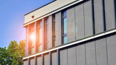 Çevre mimarisi. Binadaki ön cam ve alüminyum panellerin detayları. Yeşil ağaç ve modern ofis binası. Doğanın ve modernliğin ahengi. 