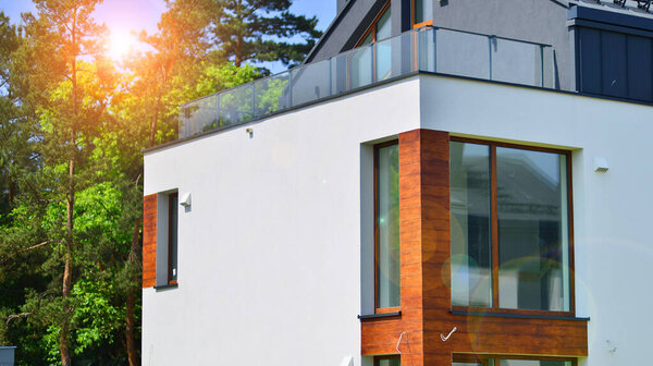 Terraced family homes in newly developed housing estate. The real estate market in the suburbs. New single family houses in a new development area. Residential homes with modern facade. 