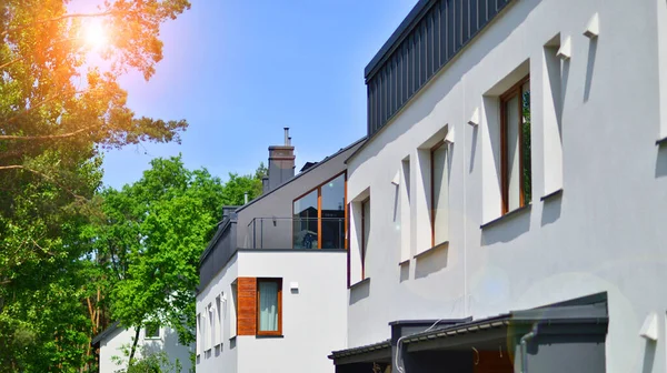 stock image Terraced family homes in newly developed housing estate. The real estate market in the suburbs. New single family houses in a new development area. Residential homes with modern facade. 