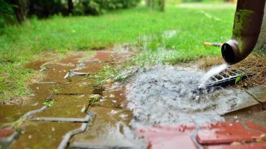 Kaldırımda şiddetli yağmur damlaları. Sel yüzeyine yağmur suyu, bahçedeki kaldırım..