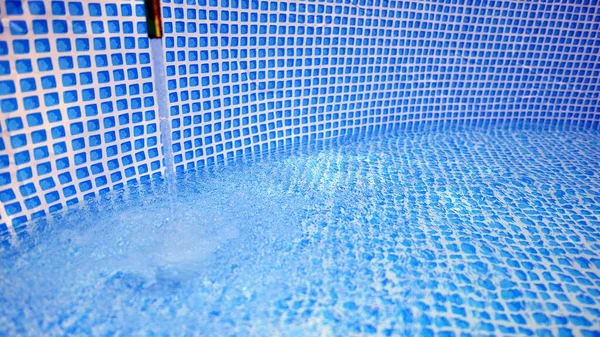 プールの充填にホースから流れる水 スイミングプールの内側 — ストック写真