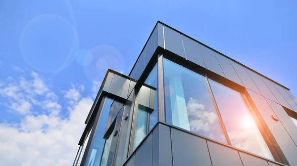 stock image Graphite facade and large windows on a fragment of an office building against a blue sky. Modern aluminum cladding facade with windows.