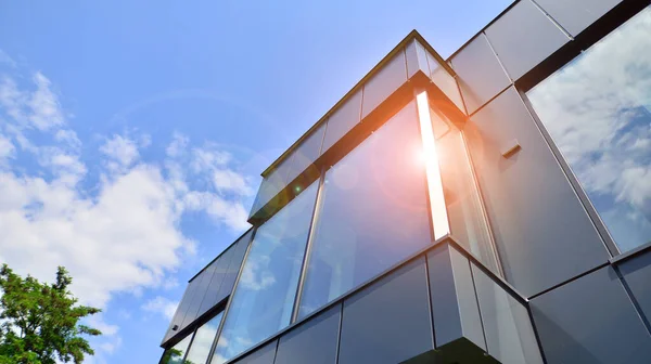 stock image Graphite facade and large windows on a fragment of an office building against a blue sky. Modern aluminum cladding facade with windows.