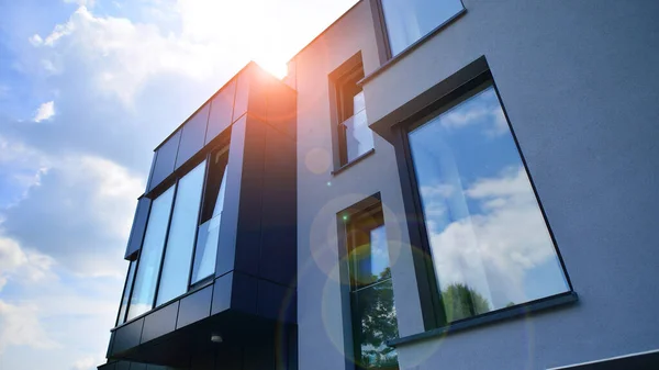 stock image Graphite facade and large windows on a fragment of an office building against a blue sky. Modern aluminum cladding facade with windows.