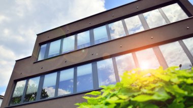 Karbondioksiti azaltmak için ağaçlı sürdürülebilir cam ofis binası. Modern şehirde çevre dostu bir bina. Yeşil çevresi olan bir ofis. Şirket binası CO2 'yi düşürdü.