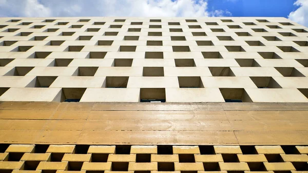 stock image Concrete building  in the chessboard style. Modern office building against blue clear sky.