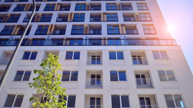 Ağaçların çevresindeki modern bir yerleşim yeri. Ekoloji ve yeşil yaşam şehirde, kentsel çevre kavramı. Modern apartman ve yeşil ağaçlar. Ekolojik konut mimarisi. 