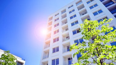 Ağaçların çevresindeki modern bir yerleşim yeri. Ekoloji ve yeşil yaşam şehirde, kentsel çevre kavramı. Modern apartman ve yeşil ağaçlar. Ekolojik konut mimarisi. 