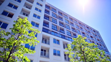 Ağaçların çevresindeki modern bir yerleşim yeri. Ekoloji ve yeşil yaşam şehirde, kentsel çevre kavramı. Modern apartman ve yeşil ağaçlar. Ekolojik konut mimarisi. 