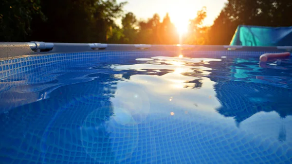 Ev ve bahçe için metal çerçeveli yüzme havuzu. Bahçedeki yüzme havuzunu çerçevele. Arka planda bahçe var. Yaz tatili eğlencesi ve eğlence.