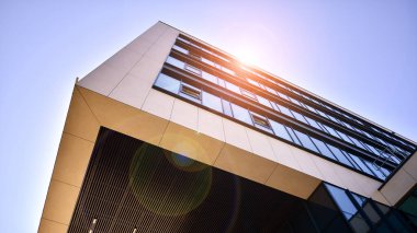 Mavi gökyüzüne karşı modern ofis binası. Modern cam bir binanın pencereleri. Ticari binalara bakıyorum..