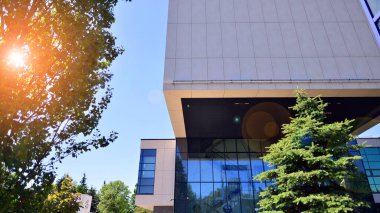 Karbondioksiti azaltmak için ağaçlı sürdürülebilir cam ofis binası. Modern şehirde çevre dostu bir bina. Yeşil çevresi olan bir ofis. Şirket binası CO2 'yi düşürdü.