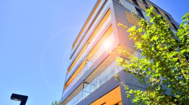 Ağaçların çevresindeki modern bir yerleşim yeri. Ekoloji ve yeşil yaşam şehirde, kentsel çevre kavramı. Modern apartman ve yeşil ağaçlar. Ekolojik konut mimarisi. 