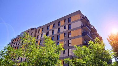 Ağaçların çevresindeki modern bir yerleşim yeri. Ekoloji ve yeşil yaşam şehirde, kentsel çevre kavramı. Modern apartman ve yeşil ağaçlar. Ekolojik konut mimarisi. 