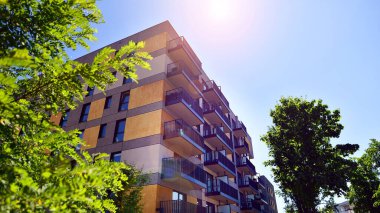 Ağaçların çevresindeki modern bir yerleşim yeri. Ekoloji ve yeşil yaşam şehirde, kentsel çevre kavramı. Modern apartman ve yeşil ağaçlar. Ekolojik konut mimarisi. 