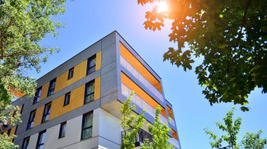 Ağaçların çevresindeki modern bir yerleşim yeri. Ekoloji ve yeşil yaşam şehirde, kentsel çevre kavramı. Modern apartman ve yeşil ağaçlar. Ekolojik konut mimarisi. 