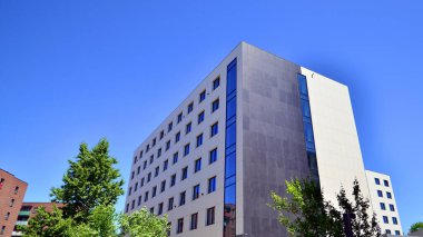Karbondioksiti azaltmak için ağaçlı sürdürülebilir cam ofis binası. Modern şehirde çevre dostu bir bina. Yeşil çevresi olan bir ofis. Şirket binası CO2 'yi düşürdü.