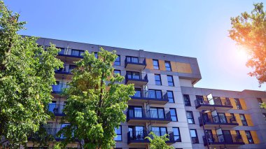 Ağaçların çevresindeki modern bir yerleşim yeri. Ekoloji ve yeşil yaşam şehirde, kentsel çevre kavramı. Modern apartman ve yeşil ağaçlar. Ekolojik konut mimarisi. 