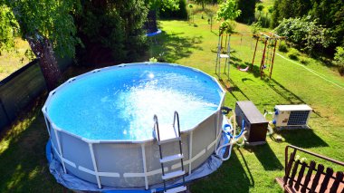 Ev ve bahçe için metal çerçeveli yüzme havuzu. Bahçedeki yüzme havuzunu çerçevele. Arka planda bahçe var. Yaz tatili eğlencesi ve eğlence.