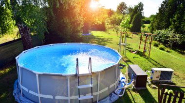 Ev ve bahçe için metal çerçeveli yüzme havuzu. Bahçedeki yüzme havuzunu çerçevele. Arka planda bahçe var. Yaz tatili eğlencesi ve eğlence.