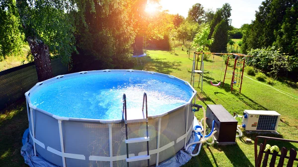 Ev ve bahçe için metal çerçeveli yüzme havuzu. Bahçedeki yüzme havuzunu çerçevele. Arka planda bahçe var. Yaz tatili eğlencesi ve eğlence.