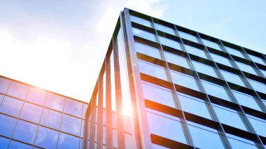 Yapısal cam duvar mavi gökyüzünü yansıtıyor. Soyut modern mimari parçası. Binanın şeffaf yüzüyle cam bina ve mavi gökyüzü. Çağdaş mimari arka plan.