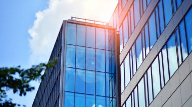 Yapısal cam duvar mavi gökyüzünü yansıtıyor. Soyut modern mimari parçası. Binanın şeffaf yüzüyle cam bina ve mavi gökyüzü. Çağdaş mimari arka plan.