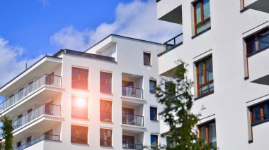 Modern residential building with new apartments in a green residential area. Eco architecture. Green tree and new apartment building. The harmony of nature and modernity.