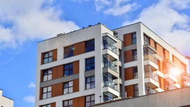 Modern residential building with new apartments in a green residential area. Eco architecture. Green tree and new apartment building. The harmony of nature and modernity.