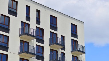  Yeşil yerleşim bölgesinde yeni daireleri olan modern bir yerleşim yeri. Çevre mimarisi. Yeşil ağaç ve yeni apartman. Doğanın ve modernliğin ahengi.