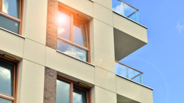  Modern residential building with new apartments in a green residential area. Eco architecture. Green tree and new apartment building. The harmony of nature and modernity.