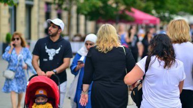 Varşova, Polonya. 29 Temmuz 2023. Sokakta yürüyen bir sürü insan. Eski bir şehir manzarasının arka planına doğru hareket eden bir kalabalık.