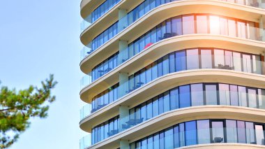 Modern, güzel, lüks otel binası. Çevre mimarisi. Yeşil ağaç ve bina. Doğanın ve modernliğin ahengi. 