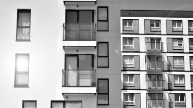 Güneşli bir günde modern apartman binası. Dış görünüş, ev cephesi. Siyah ve beyaz.