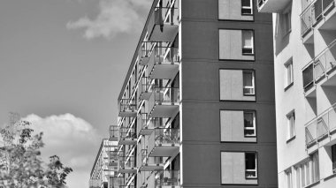 Güneşli bir günde modern apartman binası. Dış görünüş, ev cephesi. Siyah ve beyaz.
