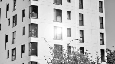 Güneşli bir günde modern apartman binası. Dış görünüş, ev cephesi. Siyah ve beyaz.