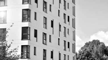 Güneşli bir günde modern apartman binası. Dış görünüş, ev cephesi. Siyah ve beyaz.