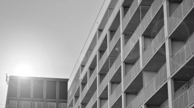Güneşli bir günde modern apartman binası. Dış görünüş, ev cephesi. Siyah ve beyaz.