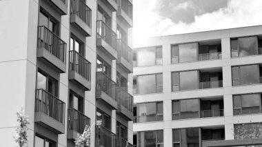 Güneşli bir günde modern apartman binası. Dış görünüş, ev cephesi. Siyah ve beyaz.