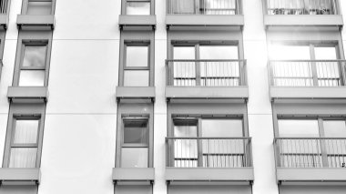 Güneşli bir günde modern apartman binası. Dış görünüş, ev cephesi. Siyah ve beyaz.