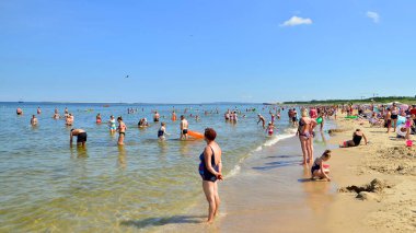 Swinoujscie, Polonya. 15 Ağustos 2023. İnsanlar Kullanım Adası 'ndaki Baltık Denizi' nin kalabalık sahillerinde dinleniyor.
