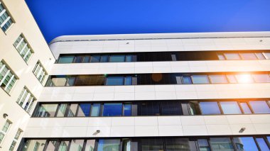 Beyaz metalik ön cepheli ve pencereli modern ofis binası. Modern mimari ayrıntılar.