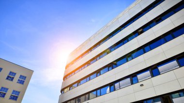 Beyaz metalik ön cepheli ve pencereli modern ofis binası. Modern mimari ayrıntılar.