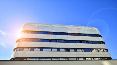 Beyaz metalik ön cepheli ve pencereli modern ofis binası. Modern mimari ayrıntılar.