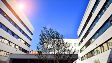 Beyaz metalik ön cepheli ve pencereli modern ofis binası. Modern mimari ayrıntılar.