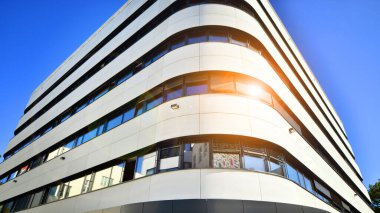 Beyaz metalik ön cepheli ve pencereli modern ofis binası. Modern mimari ayrıntılar.