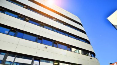 Beyaz metalik ön cepheli ve pencereli modern ofis binası. Modern mimari ayrıntılar.