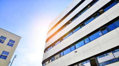 Beyaz metalik ön cepheli ve pencereli modern ofis binası. Modern mimari ayrıntılar.