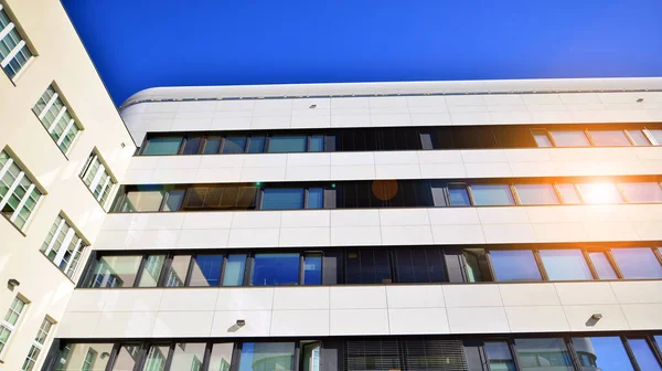 Beyaz metalik ön cepheli ve pencereli modern ofis binası. Modern mimari ayrıntılar.