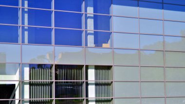 Mimarlık detayları. Güneşli bir günde modern cam bina cephesi. İş geçmişi.